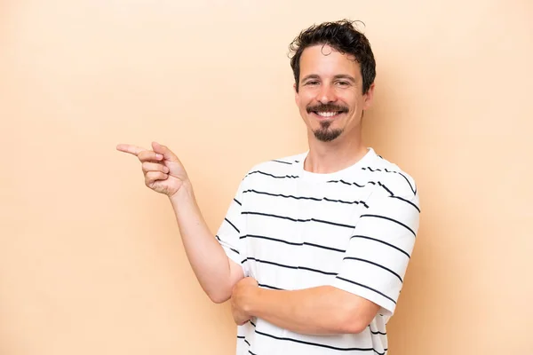 Young Caucasian Man Isolated Beige Background Pointing Finger Side — Foto de Stock