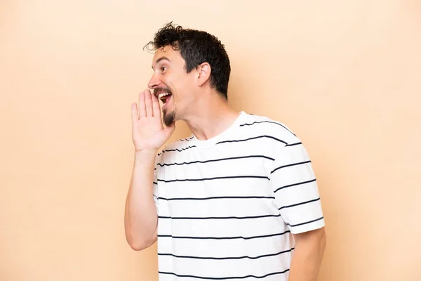 Young Caucasian Man Isolated Beige Background Shouting Mouth Wide Open — Foto de Stock