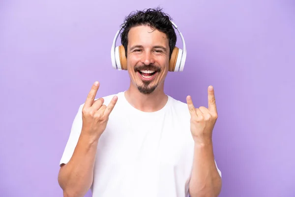 Young Caucasian Man Isolated Purple Background Listening Music Making Rock — Stock Photo, Image