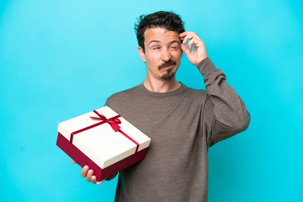 Young Man Holding Gift Having Doubts Confuse Face Expression — Foto Stock