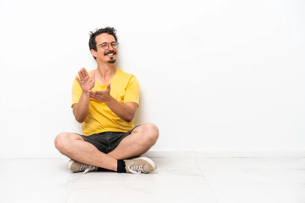 Young Caucasian Man Sitting Floor Isolated White Background Applauding Presentation — Foto de Stock