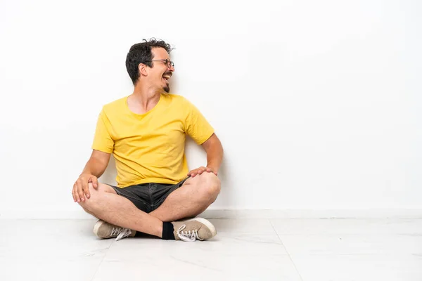 Young Caucasian Man Sitting Floor Isolated White Background Laughing Lateral — Foto de Stock