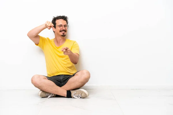 Young Caucasian Man Sitting Floor Isolated White Background Points Finger — Stock fotografie