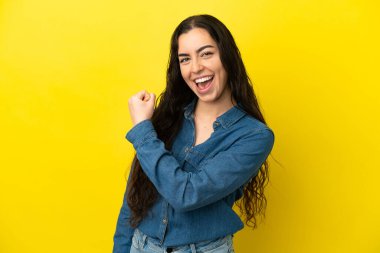 Sarı arka planda izole edilmiş beyaz bir kadın zaferi kutluyor.