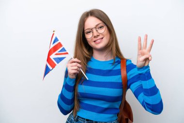 Beyaz arka planda izole edilmiş bir Birleşik Krallık bayrağı taşıyan beyaz kadın mutlu ve parmaklarıyla üçe kadar sayıyor.