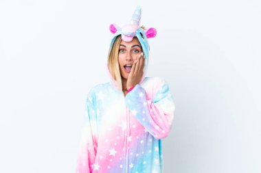 Blonde Uruguayan girl wearing a unicorn pajama isolated on white background with surprise and shocked facial expression