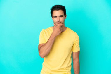 Izole mavi arka plan düşünme üzerinde Kafkas yakışıklı adam