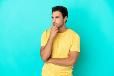 Izole mavi arka plan sinirli ve korkmuş üzerinde Kafkas yakışıklı adam