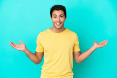 Şok yüz ifadesi ile izole mavi arka plan üzerinde Kafkas yakışıklı adam