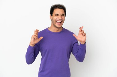 Caucasian handsome man over isolated white background with fingers crossing