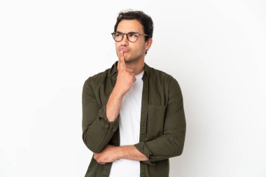 Caucasian handsome man over isolated white background having doubts while looking up