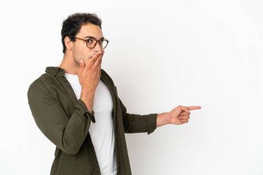 Caucasian handsome man over isolated white background with surprise expression while pointing side