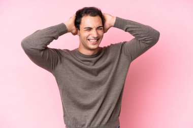 Pembe arka planda izole edilmiş genç beyaz adam gülüyor.