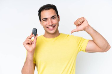 Young caucasian man holding car keys isolated on white background proud and self-satisfied