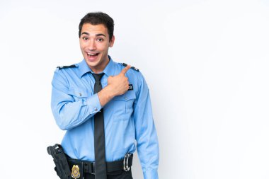Young police caucasian man isolated on white background surprised and pointing side