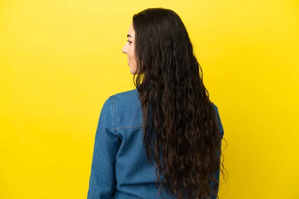 Mulher Caucasiana Jovem Isolado Fundo Amarelo Posição Traseira Olhando Lado — Fotografia de Stock