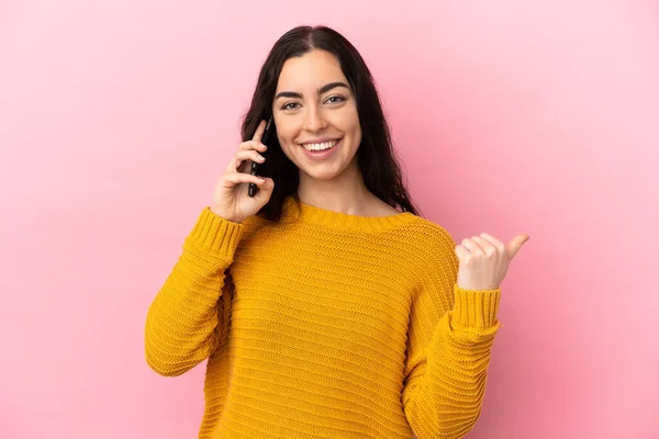 Young Caucasian Woman Using Mobile Phone Isolated Pink Background Pointing —  Fotos de Stock