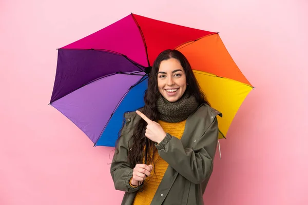 Jovem Segurando Guarda Chuva Isolado Fundo Rosa Apontando Para Lado — Fotografia de Stock