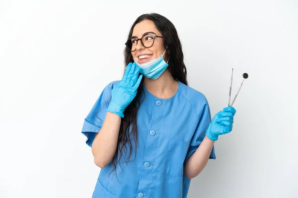 Młoda Kobieta Dentysta Trzyma Narzędzia Izolowane Białym Tle Patrząc Górę — Zdjęcie stockowe