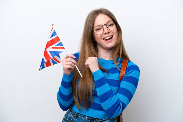 Молодая кавказка с флагом Великобритании на белом фоне празднует победу
