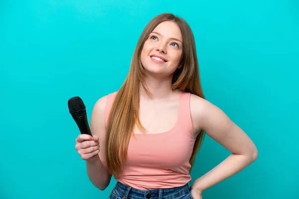 Kafkasyalı Şarkıcı Mavi Arka Planda Izole Edilmiş Bir Mikrofonu Kaldırırken — Stok fotoğraf