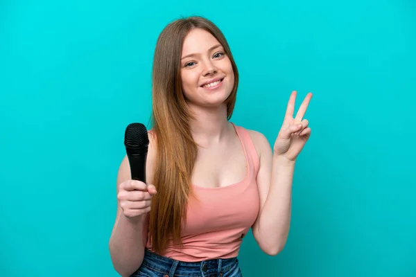 Singer Caucasian Woman Picking Microphone Isolated Blue Background Smiling Showing — Stok fotoğraf