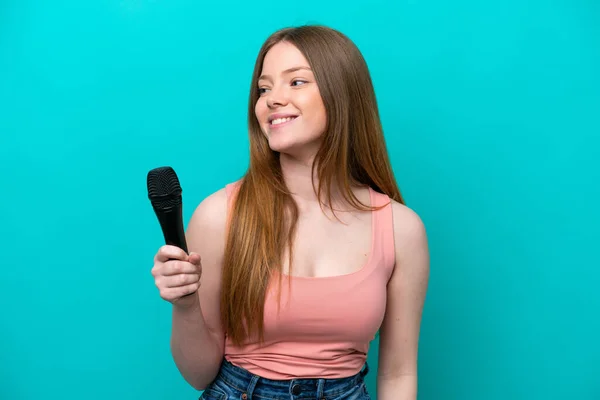 Singer Caucasian Woman Picking Microphone Isolated Blue Background Looking Side — Stok fotoğraf