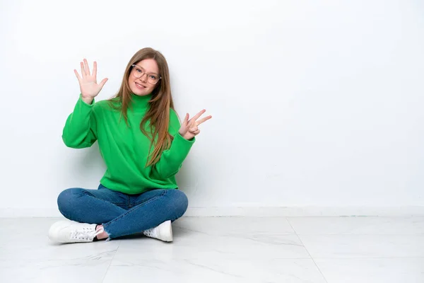 Mladá Běloška Žena Sedí Podlaze Izolované Bílém Pozadí Počítání Osm — Stock fotografie