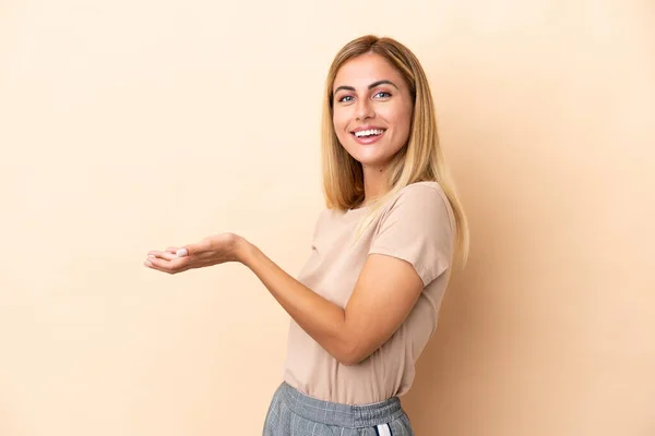 Blonde Uruguayan Girl Isolated Beige Background Presenting Idea While Looking — Zdjęcie stockowe