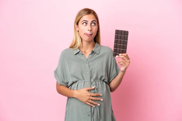 Mladá Uruguayská Žena Izolované Modrém Pozadí Těhotná Drží Čokoládu Hladem — Stock fotografie