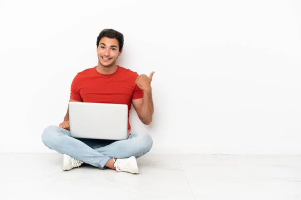 Caucasian Handsome Man Laptop Sitting Floor Pointing Side Present Product — Foto Stock