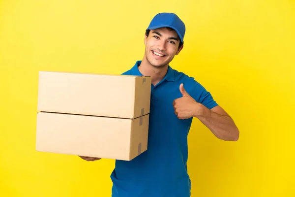 Delivery Man Isolated Yellow Wall Giving Thumbs Gesture — Stockfoto