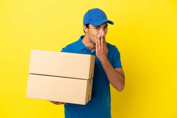 Delivery Man Isolated Yellow Wall Happy Smiling Covering Mouth Hand — Stockfoto