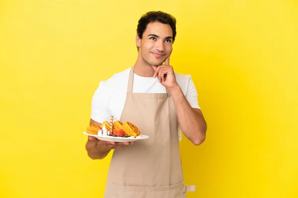 Restaurant Waiter Holding Waffles Isolated Yellow Background Thinking Idea While — Stockfoto
