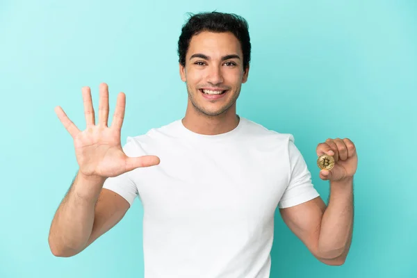 Young Man Holding Bitcoin Isolated Blue Background Counting Five Fingers — 스톡 사진