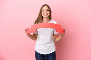 Genç Litvanyalı bir kadın pembe arka planda izole edilmiş. Elinde boş bir pankart var.