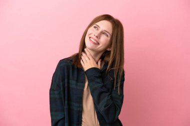 Genç İngiliz kadın pembe arka planda izole edilmiş gülümserken yukarı bakıyor