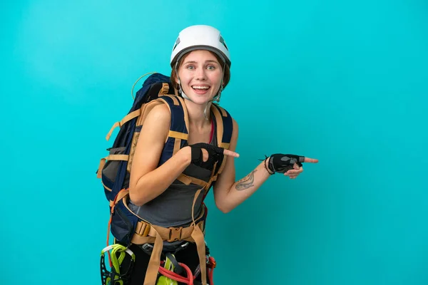 Jovem Inglesa Alpinista Mulher Isolada Fundo Azul Surpreso Apontando Lado — Fotografia de Stock