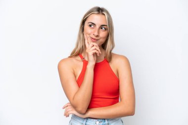 Beyaz arka planda izole edilmiş genç beyaz kadın yukarı bakarken bir fikir düşünüyor.