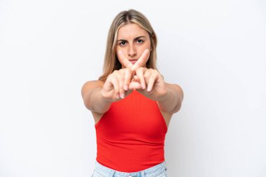 Beyaz arka planda izole edilmiş genç beyaz bir kadın bir eylemi durdurmak için el hareketi yapıyor.