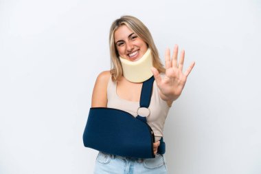 Kırık kollu ve askısı beyaz arka planda olan beş parmaklı bir kadın.