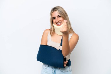 Woman with broken arm and wearing a sling isolated on white background making money gesture