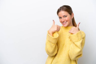 Beyaz arka planda izole edilmiş genç beyaz bir kadın baş parmak hareketi yapıyor.