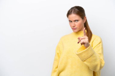 Beyaz arka planda izole edilmiş genç beyaz kadın hayal kırıklığına uğramış ve ön tarafı işaret ediyor.