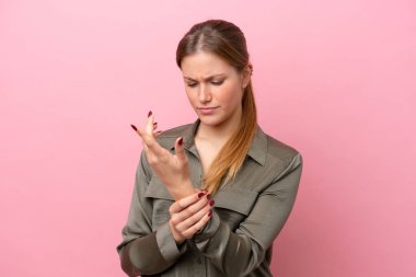 Pembe arka planda izole edilmiş beyaz bir kadın ellerinde acıdan muzdarip.