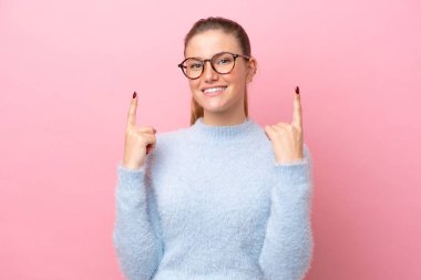 Pembe arka planda izole edilmiş beyaz bir kadın harika bir fikre işaret ediyor.