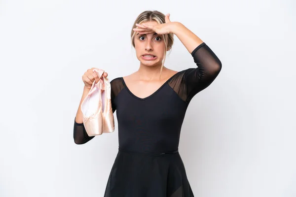年轻的高加索女人在练习芭蕾时 独立于白人背景之外 一边向旁边看一边做着令人惊讶的手势 — 图库照片