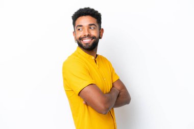 Genç Brezilyalı bir adam beyaz arka planda izole edilmiş, yana bakıyor ve gülümsüyor.