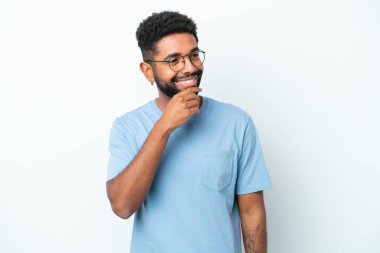 Genç Brezilyalı bir adam beyaz arka planda izole edilmiş, yana bakıyor ve gülümsüyor.