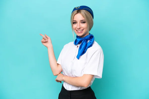 Samolot Blondynka Stewardessa Kobieta Odizolowany Niebieskim Tle Wskazując Palcem Bok — Zdjęcie stockowe
